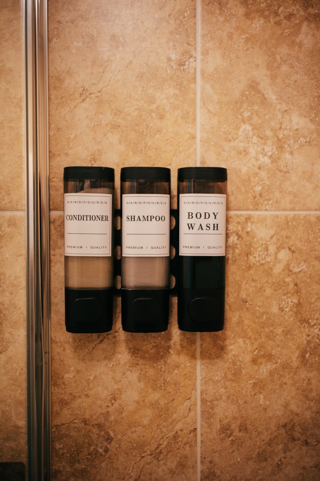 Shampoo, conditioner and body wash dispensers on the shower wall